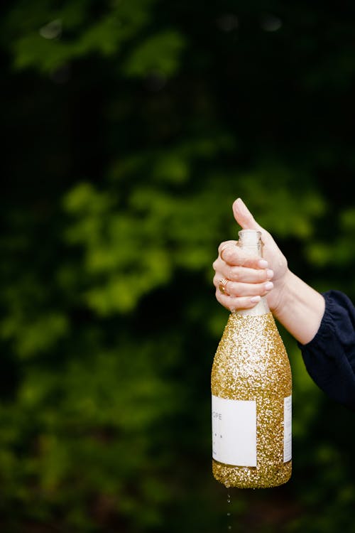 Woman Hand Holding Bottle of Alcohol