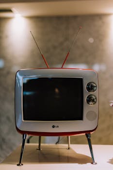 Close-up of a retro television with antennae on a table, capturing nostalgia.
