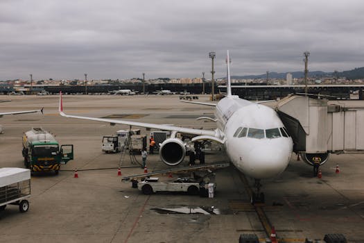 Airplane being prepared at São Paulo airport with jet bridge and ground crew.