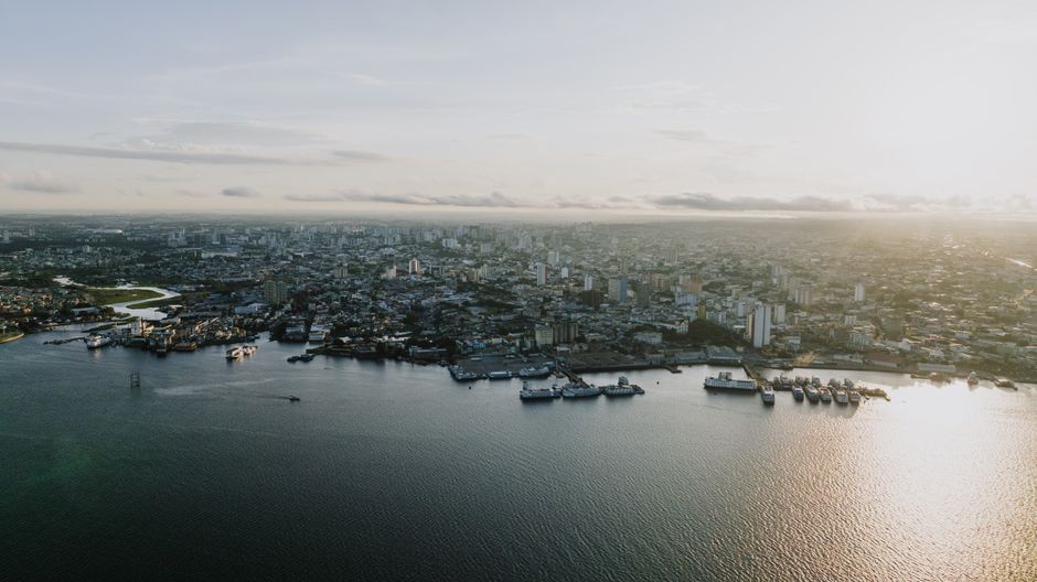 A breathtaking aerial view of Manaus' cityscape and waterfront at sunset.