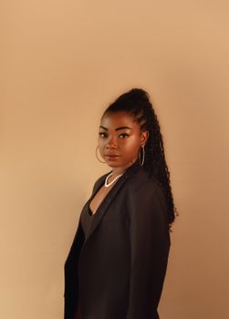 Sophisticated portrait of a young woman showcasing fashion and style in a studio setting.