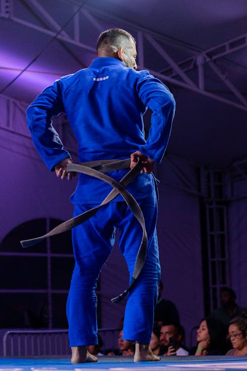 Free Man in Blue Kimono Tying a Black Belt Stock Photo