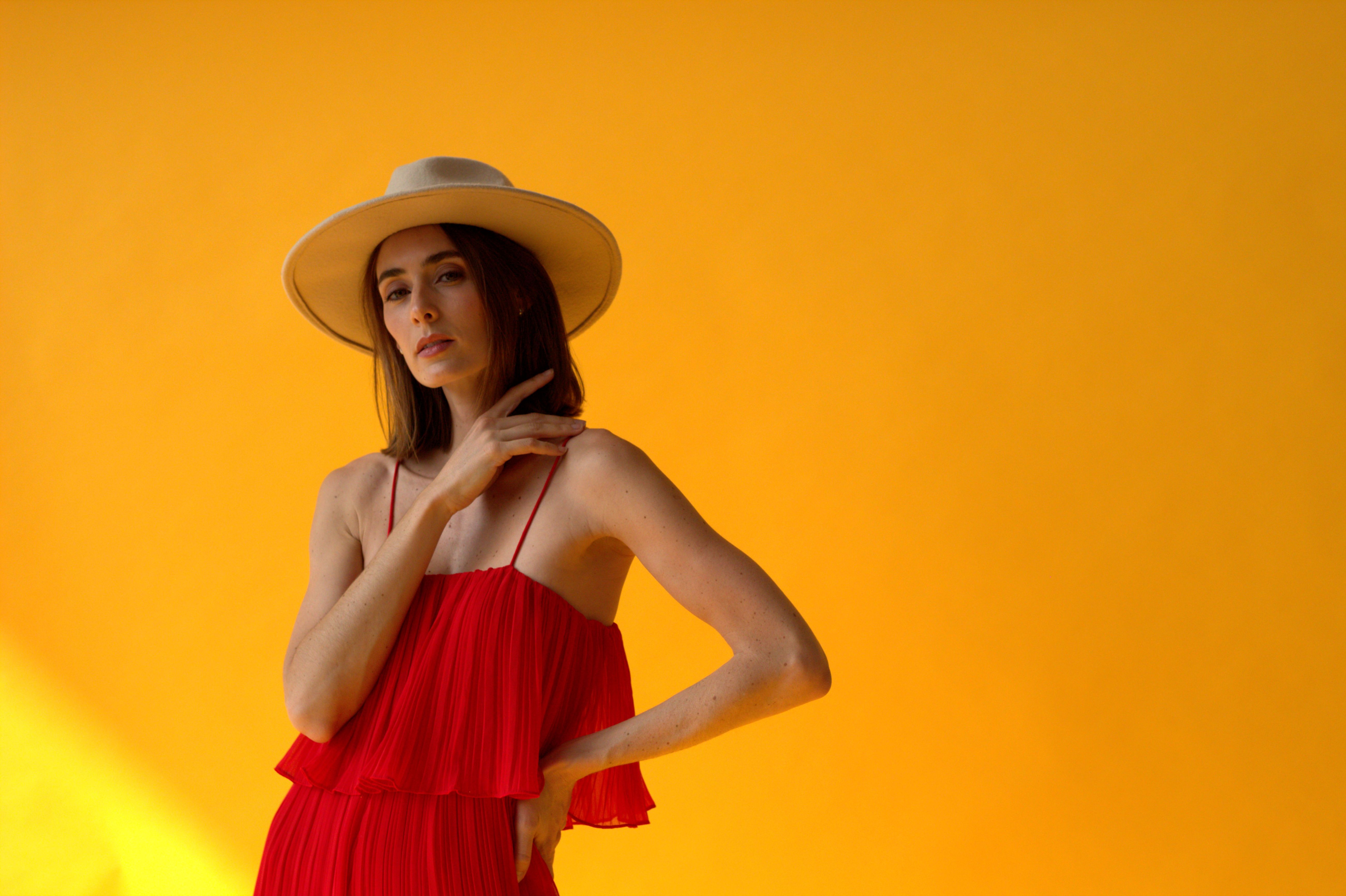 Woman in Red Dress and Straw Hat Posing on Yellow Ba · Free Stock Photo