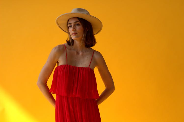 Woman In Red Sundress And Hat On Yellow Back