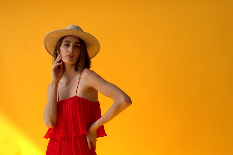 Woman In Red Sundress Posing On Yellow Ba