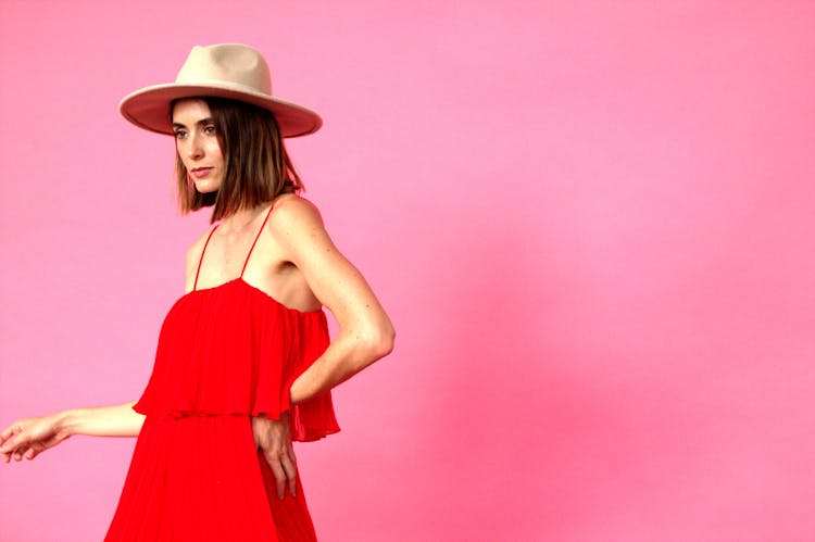 Woman In Red Sundress Standing On Pink Back