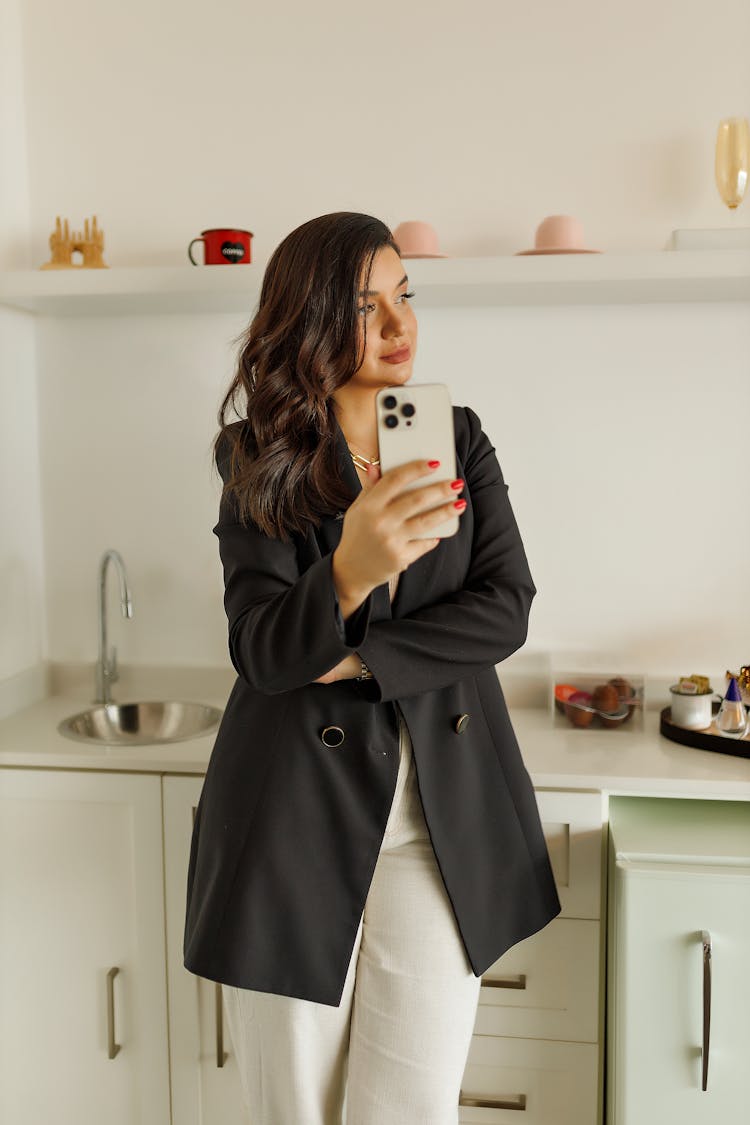 A Woman Holding Phone In The Kitchen