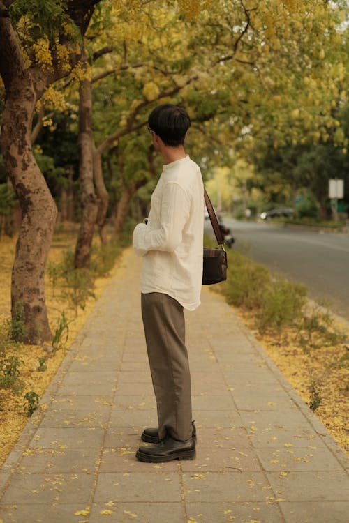 Man in White Shirt Standing on Sidewalk