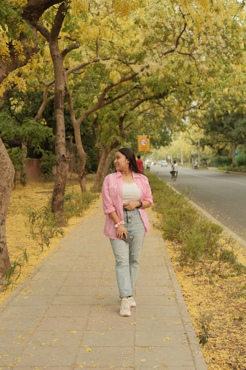 Foto profissional grátis de andando, árvores, blusa rosa