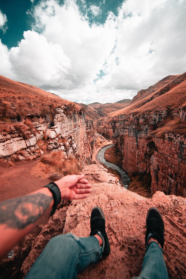 Arm And Legs Of Man Sitting Over Canyon