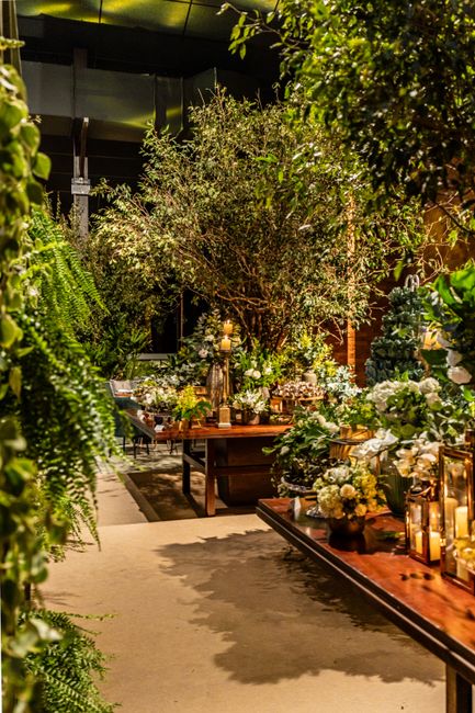 A beautifully styled garden event with lush greenery and candlelit tables for an enchanting ambiance.