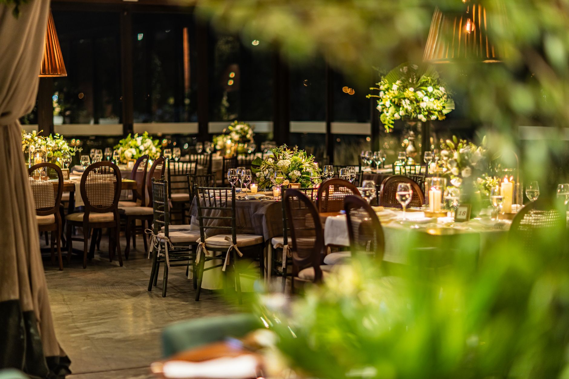 A sophisticated fine dining table setting in a prestigious restaurant with a blurred city view at night.