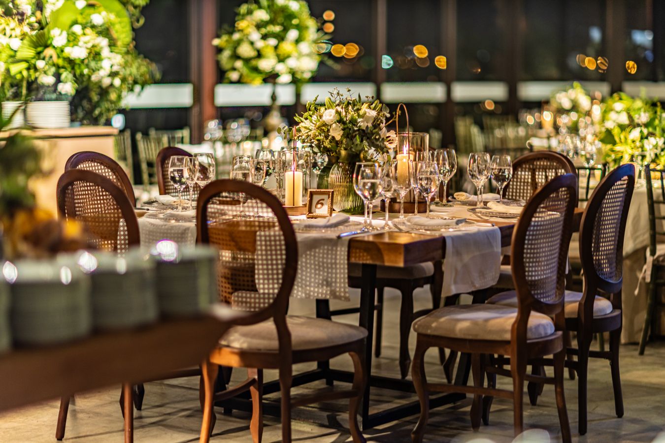 Mesa de recepción de boda con centro de mesa, velas y tarjeta numerada