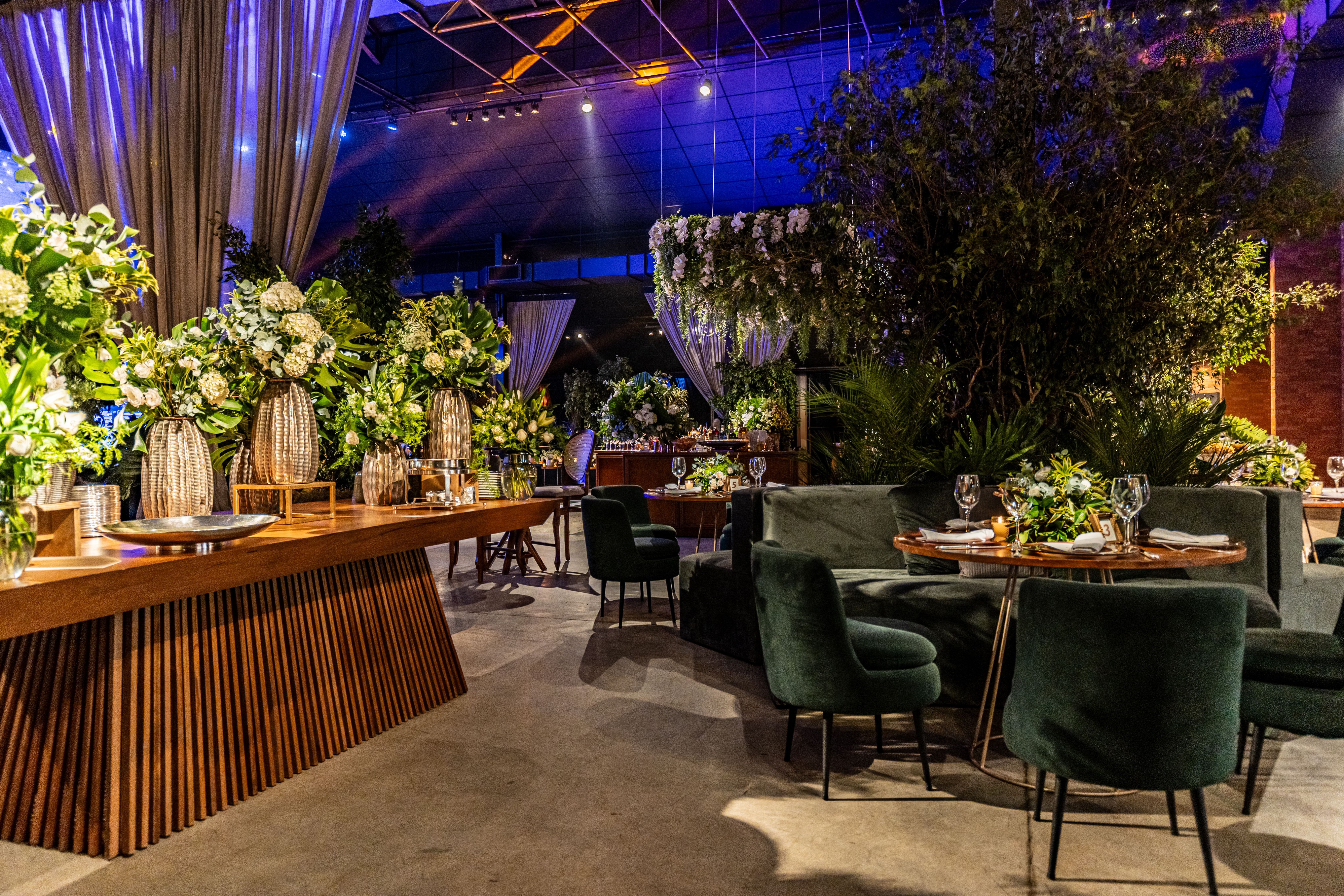 Chic indoor banquet setup featuring lush green floral arrangements and modern table settings.
