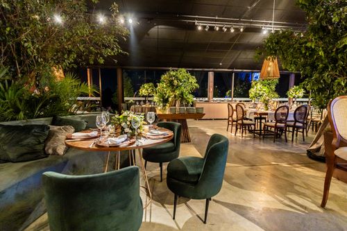 Free Luxurious restaurant setting featuring round tables, elegant decor, and lush greenery. Stock Photo
