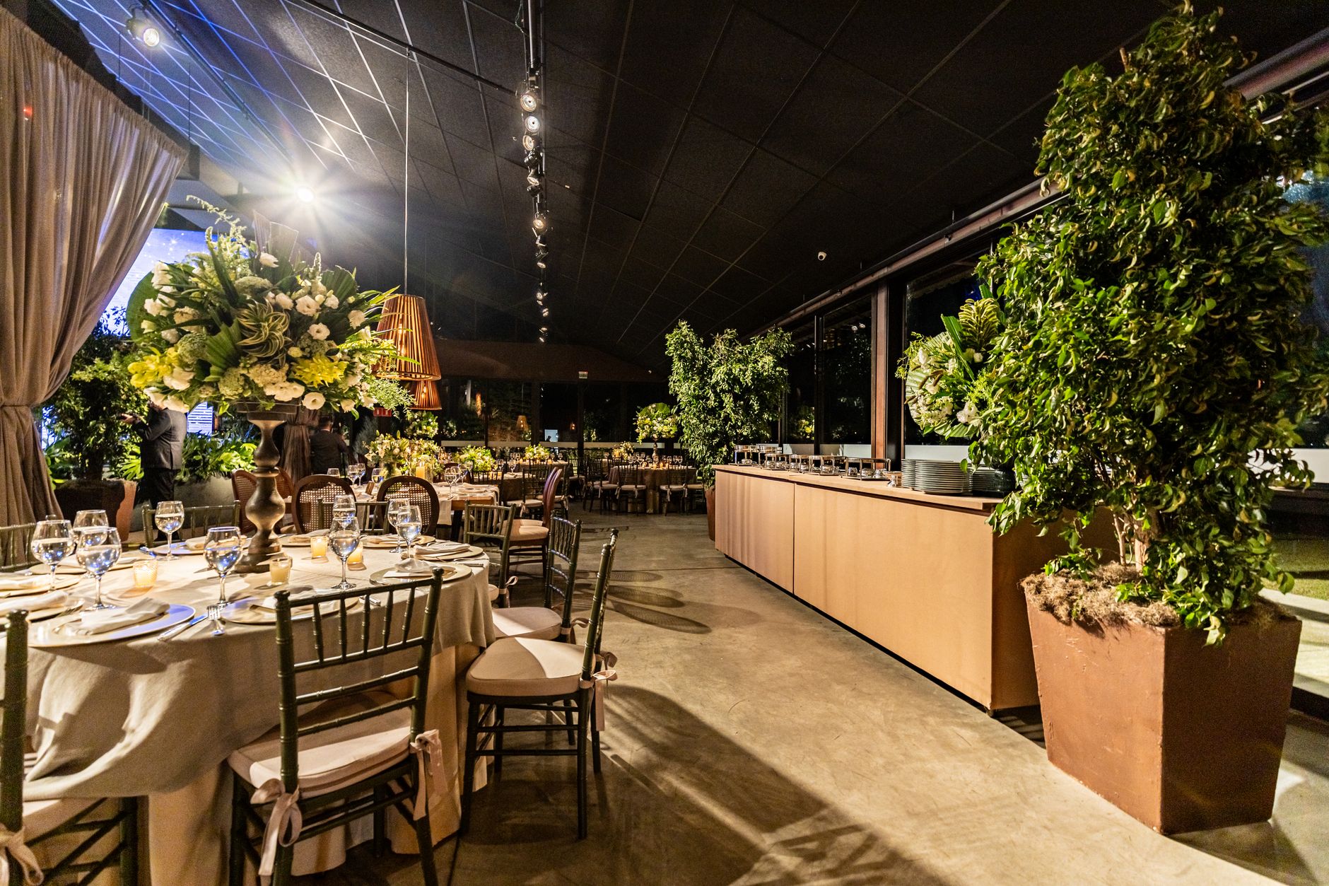 Chic indoor dining area with floral arrangements, elegant table settings, and warm lighting.