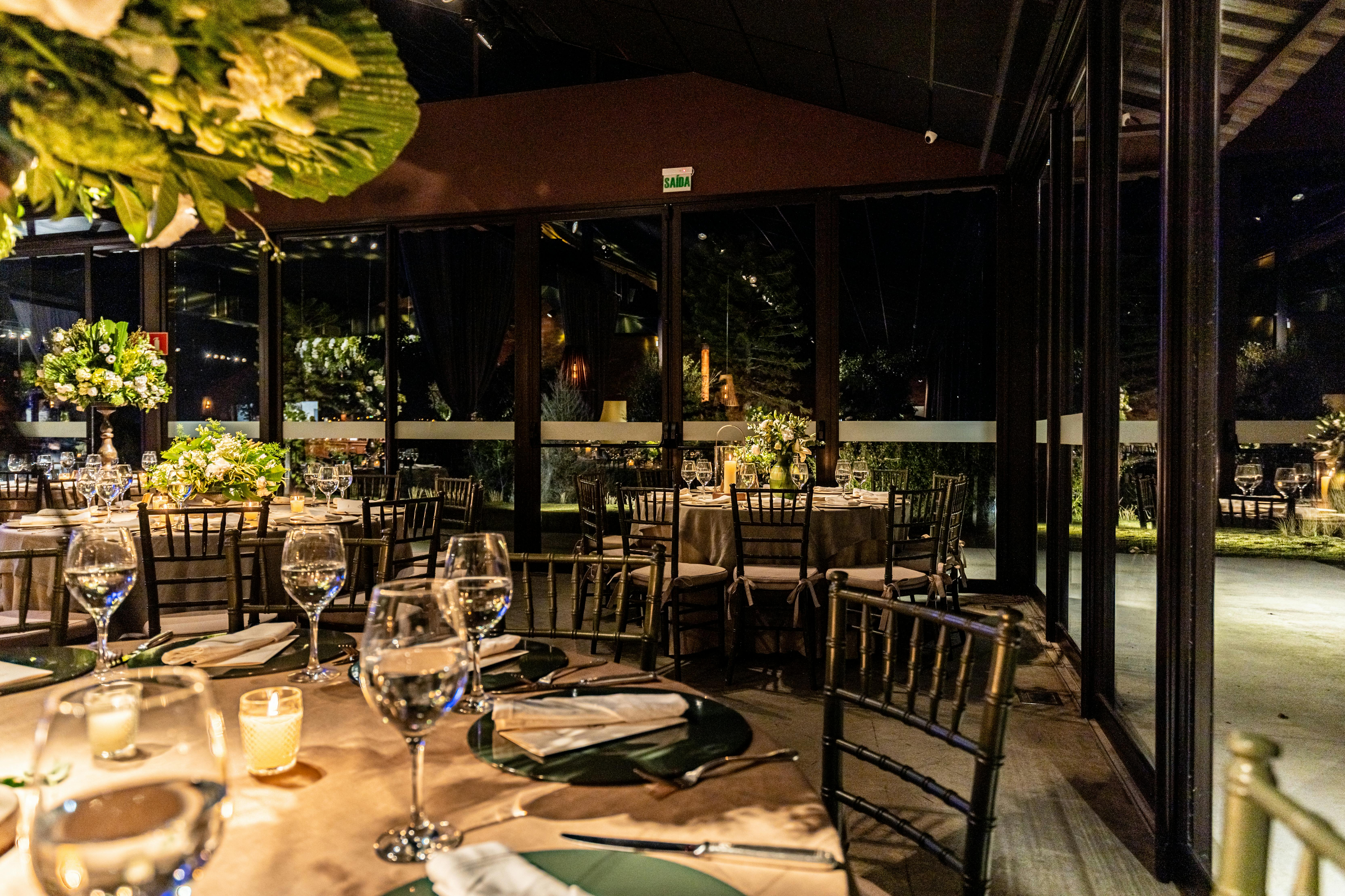 An elegant restaurant setting with beautifully arranged tables and warm lighting at night.