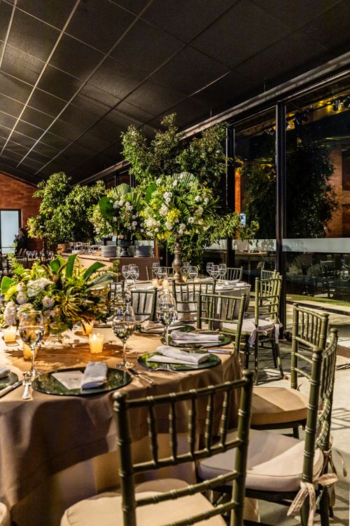 Free Stylish indoor event featuring round tables adorned with floral centerpieces and elegant tableware. Stock Photo