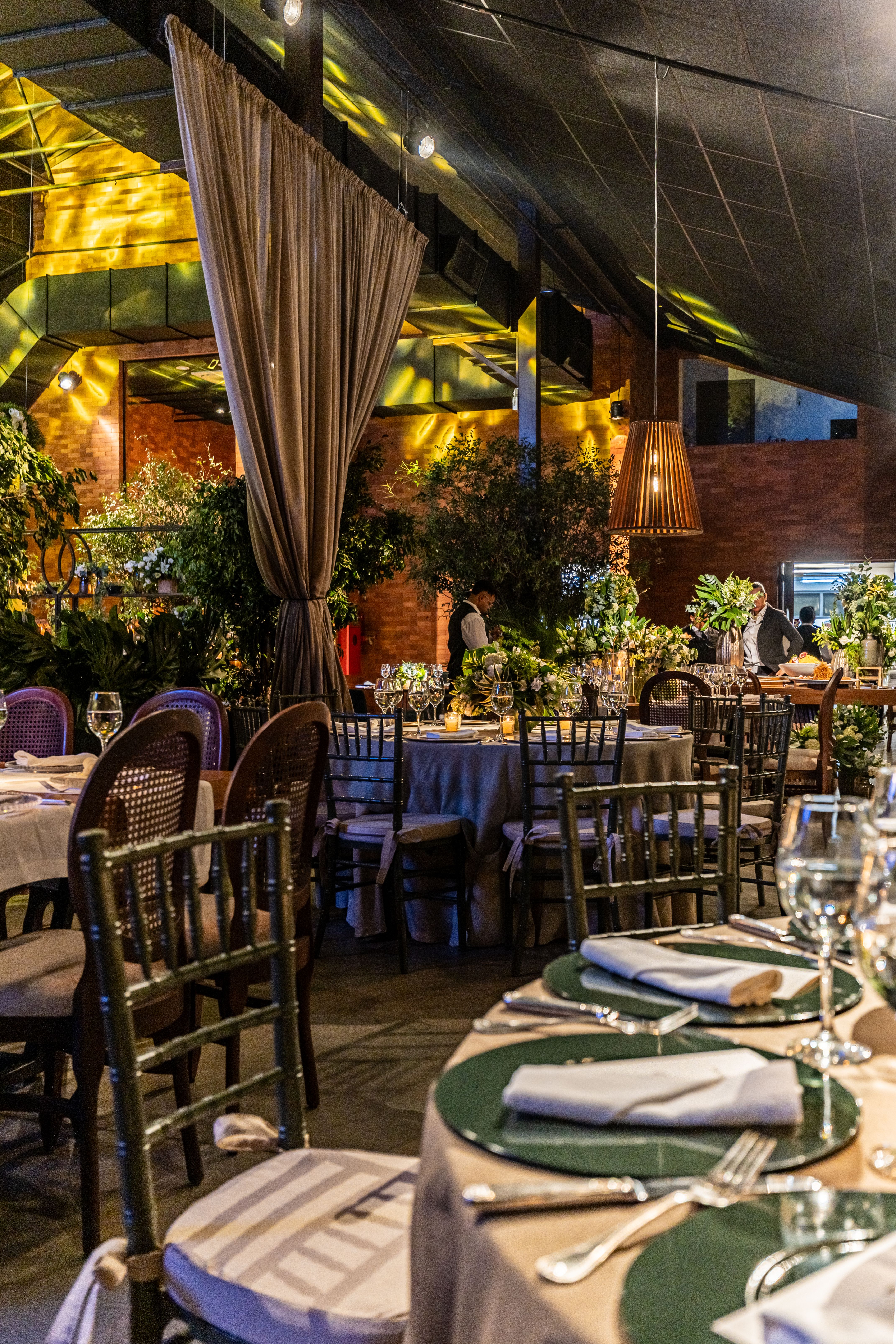Luxurious banquet hall featuring elegant table settings, floral arrangements, and warm lighting.
