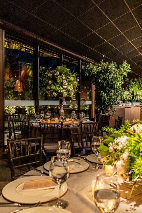 Free Luxurious indoor event setup with floral decorations, elegant tableware, and ambient lighting. Stock Photo