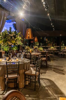 Beautifully decorated restaurant interior with tables set for a celebration, featuring floral arrangements and ambient lighting.