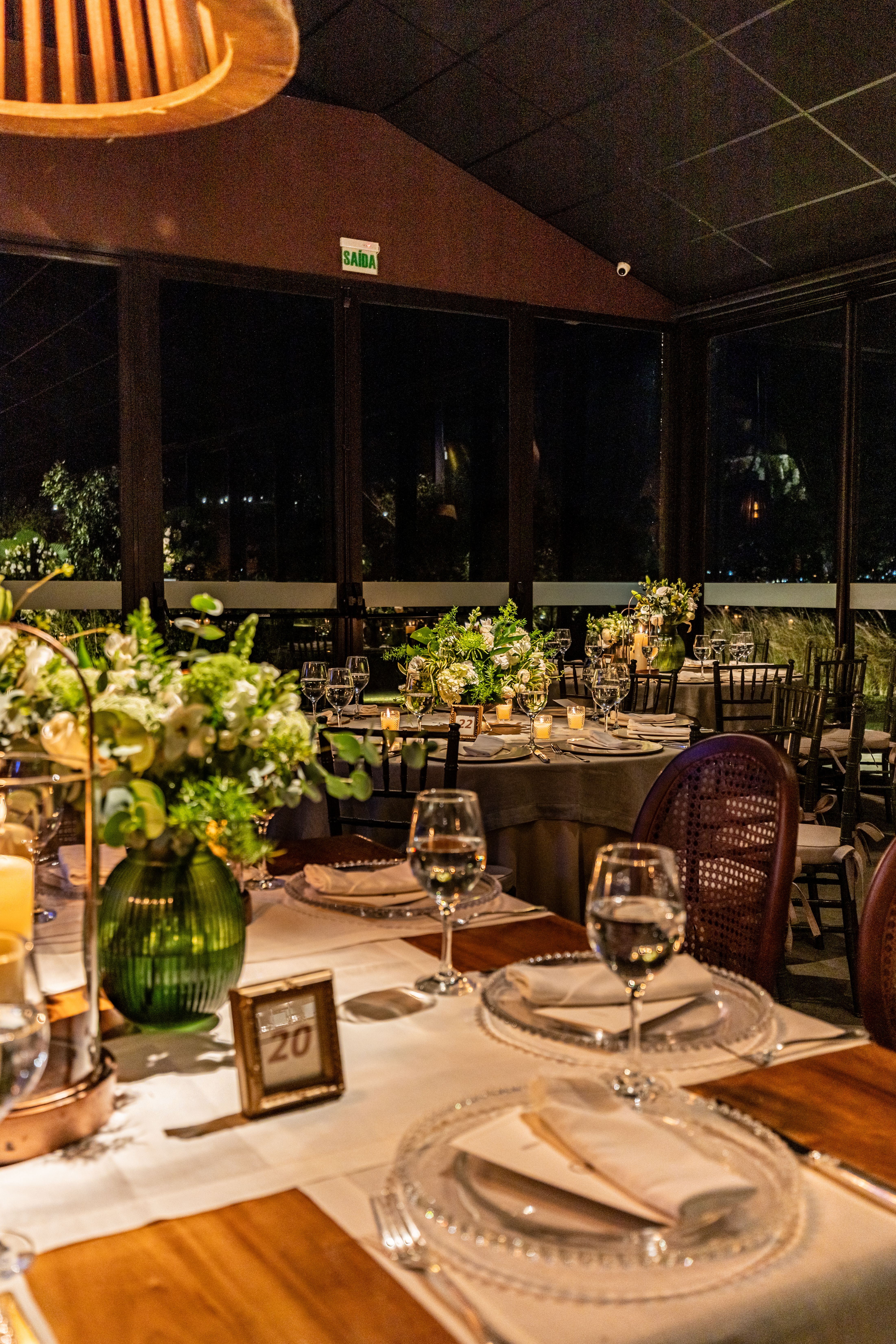 Beautifully arranged banquet table set for a wedding with floral decorations and wineglasses.