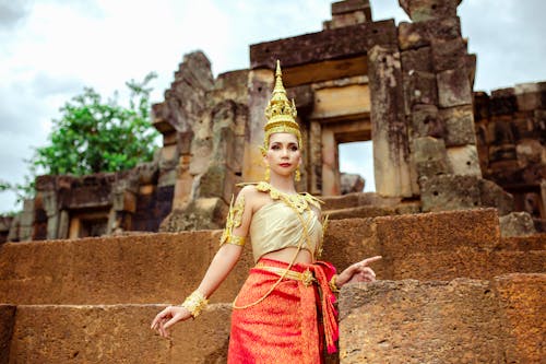 Woman in a Traditional Costume Standing in front of a Temple 