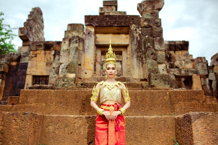 Woman In A Traditional Costume Standing In Front Of A Temple 