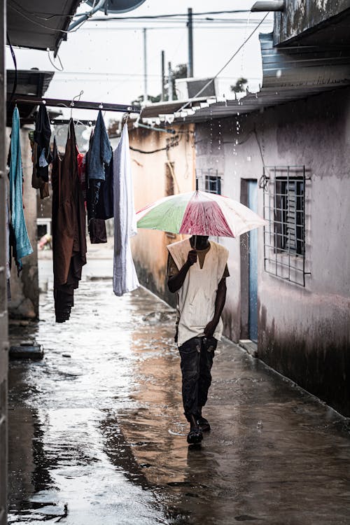 Woman Walking with Umbrella During Rain