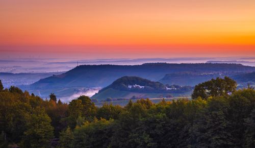 Free A stunning landscape showcasing a tranquil sunrise over lush, rolling hills and forests. Stock Photo