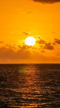 Vibrant sunset over the ocean in Rasdhoo, Maldives with golden sky reflections.
