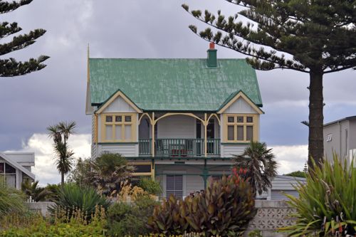 Free Victorian house with a green roof in Napier, showing unique architecture amid lush vegetation. Stock Photo