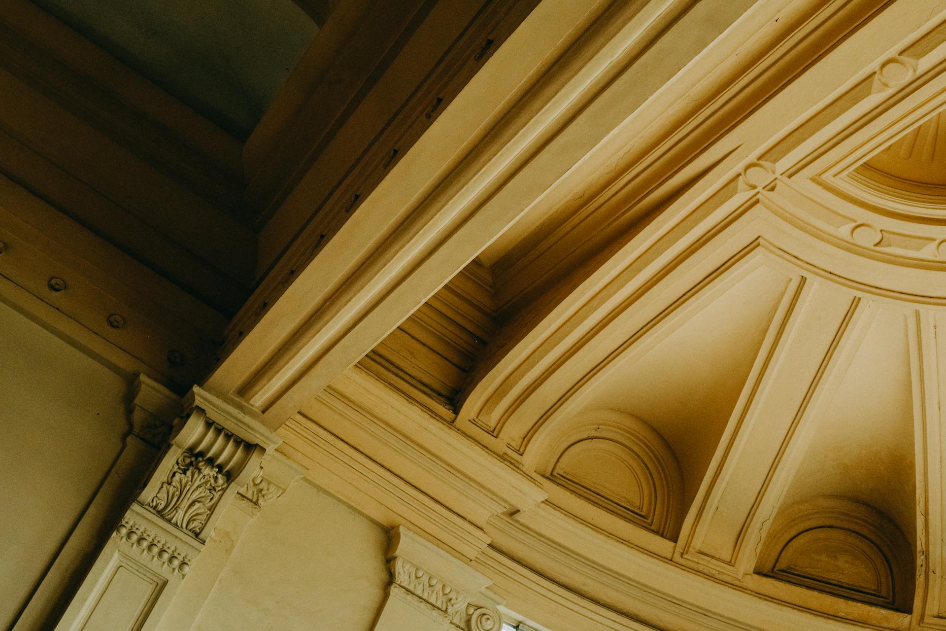 Intricate classical architecture featuring arches and ornate ceiling details in a warm color palette.