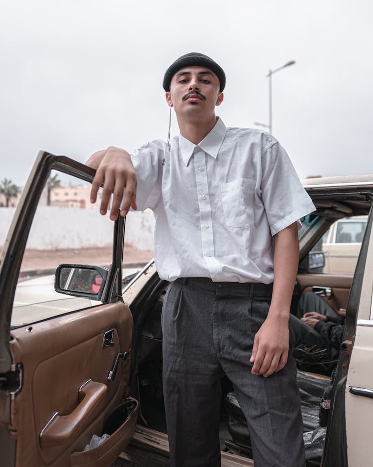 Man In White Shirt Posing In Open Car Door