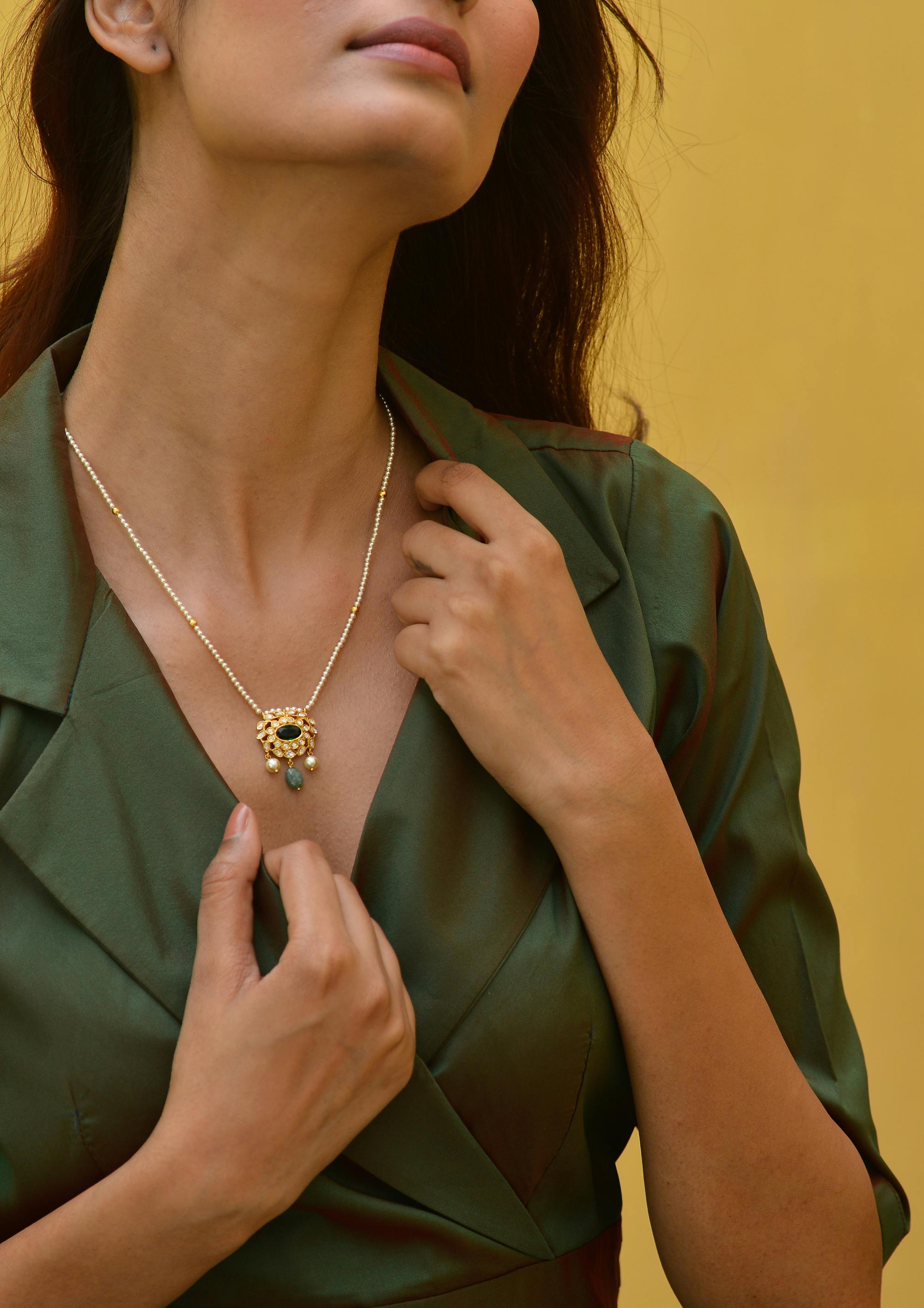 golden necklace on woman neck posing in studio