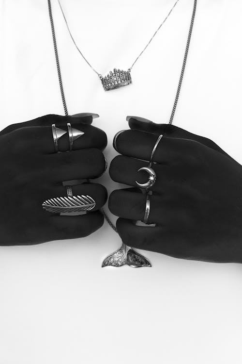 Hands in Gloves Holding Necklaces