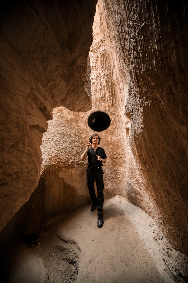 Man Posing And Throwing Hat In Canyon