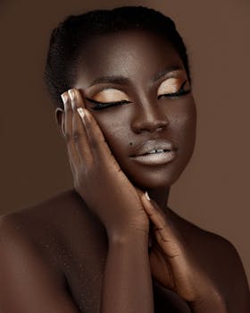 A captivating portrait of a woman with stylish makeup posing with closed eyes against a brown background.
