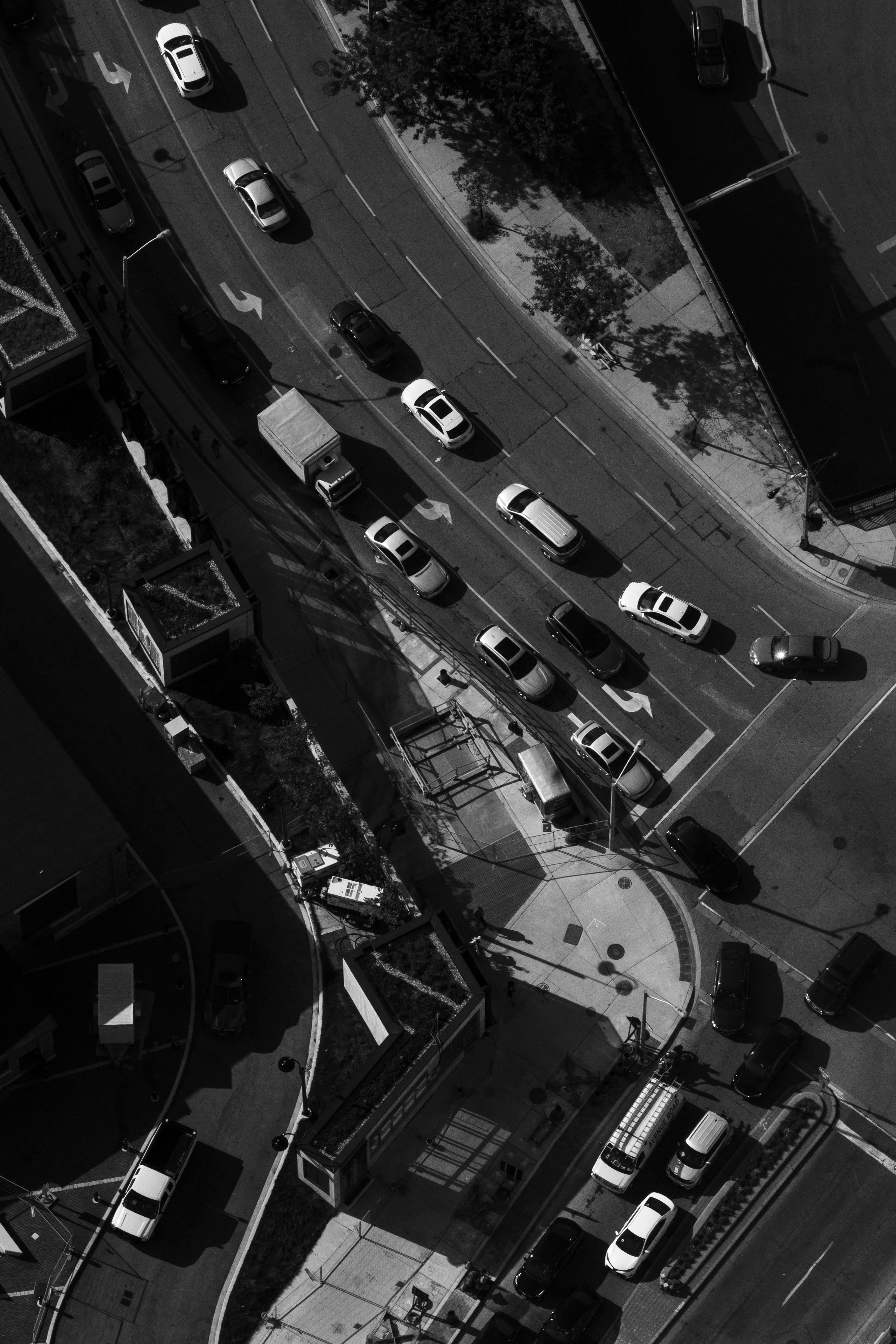 Black and white aerial shot of bustling traffic in downtown Toronto, capturing urban life.