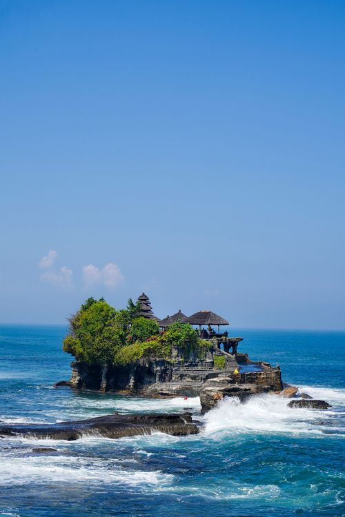 Free Majestic Tanah Lot Temple on rocky coast in Bali, vibrant blue sea and clear sky. Stock Photo