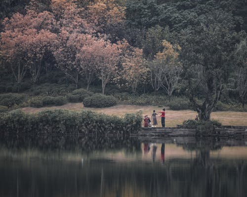 Free Landscape with Trees, and People Standing by a Pond Stock Photo