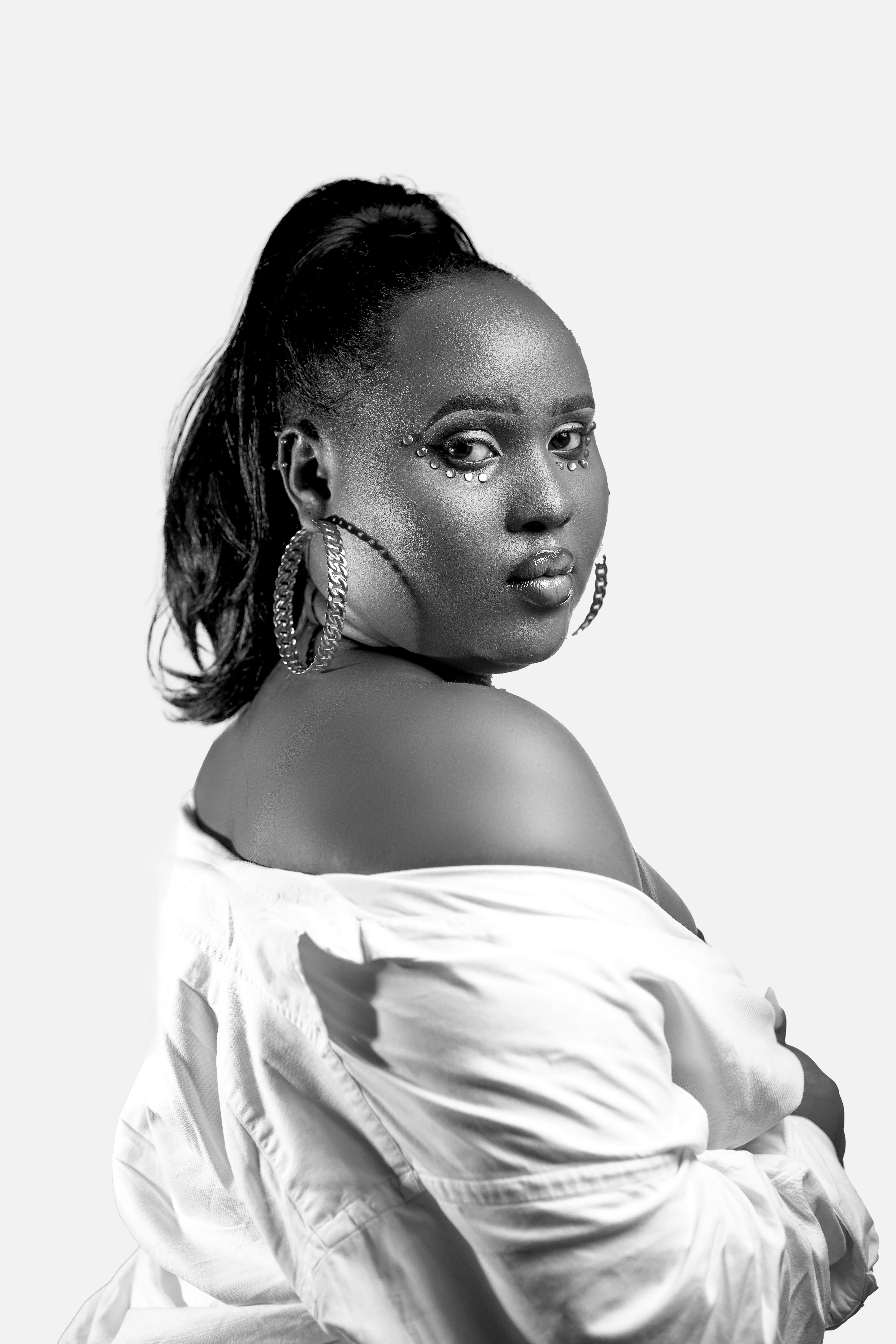 Stunning black and white portrait of a woman with hoop earrings in a studio setup.