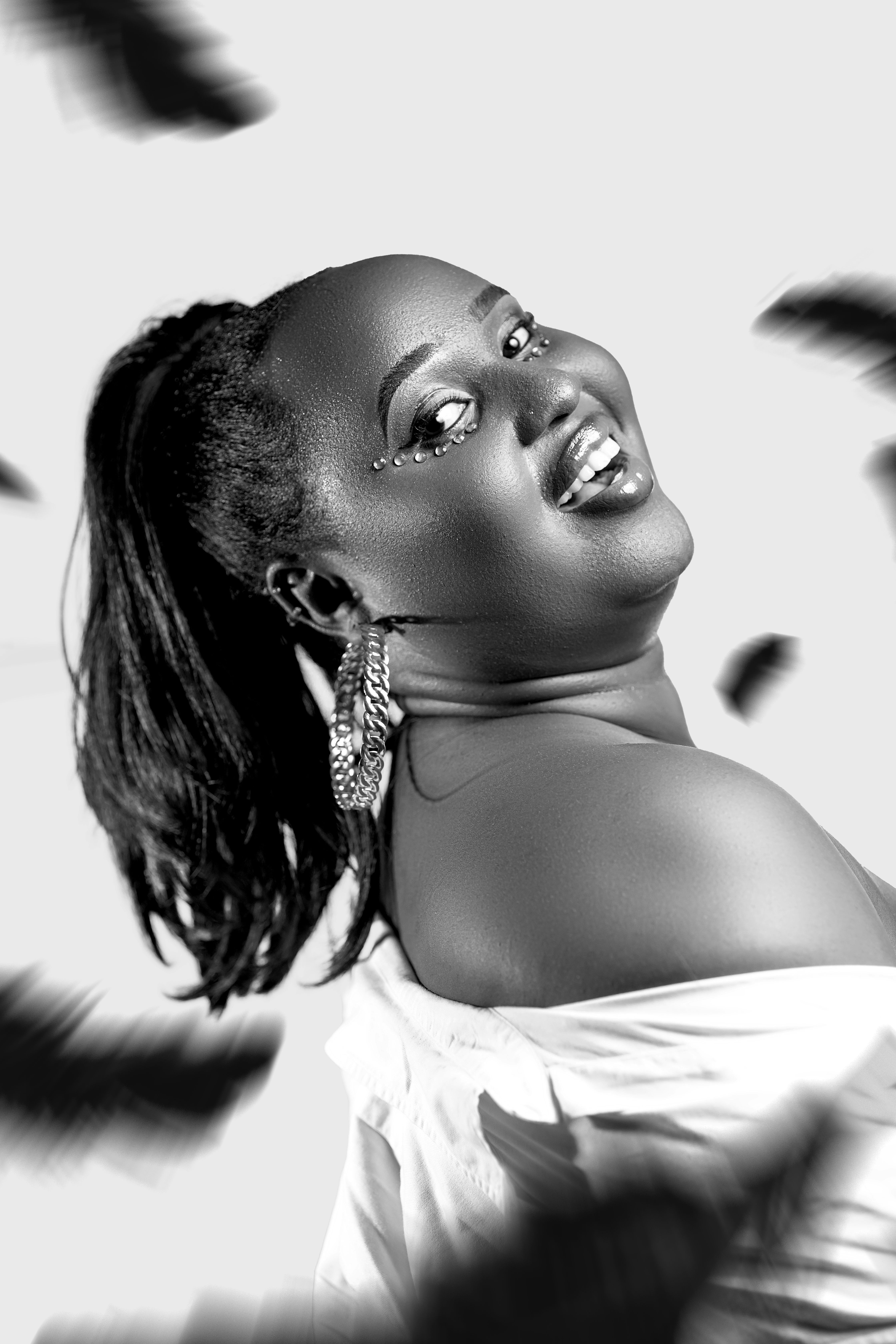 Stunning monochrome portrait of a joyful woman with elegant earrings.