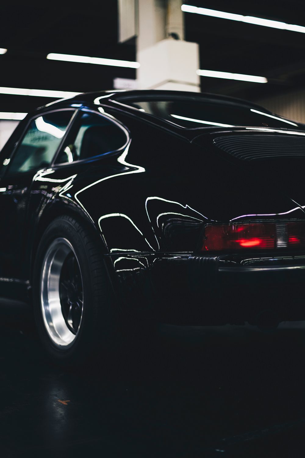 Glossy black classic vehicle reflecting studio lights