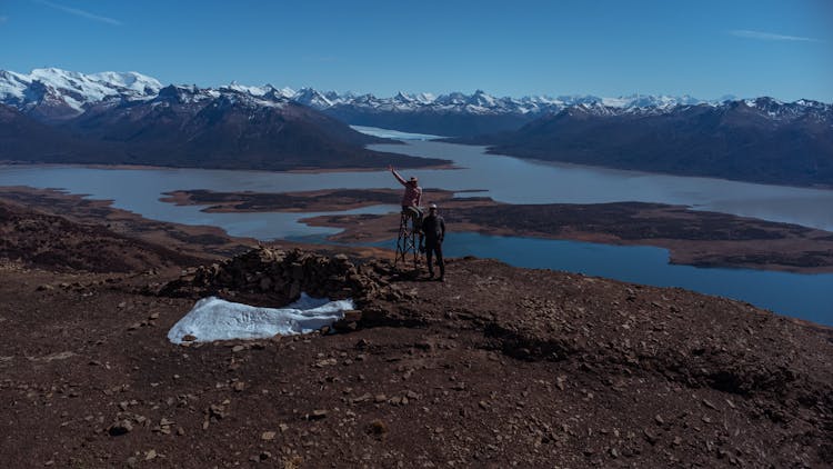 People Near Lake In Mountains In Argentina