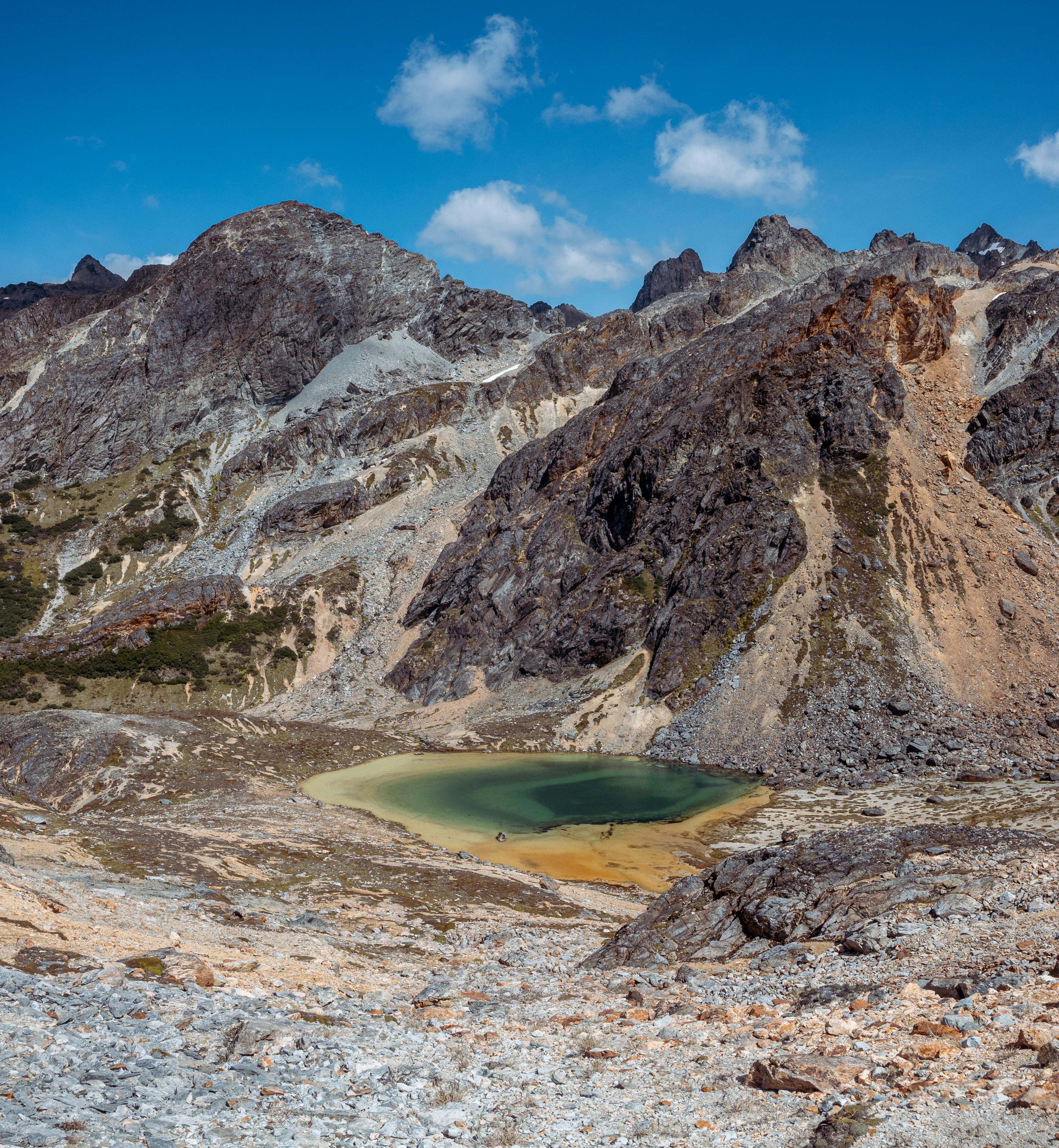 Stunning rocky mountains and a serene lake under a bright blue sky.