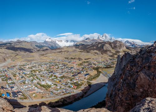 Free Stunning aerial shot of El Chaltén, capturing its village nestled among towering mountains and a winding river. Stock Photo