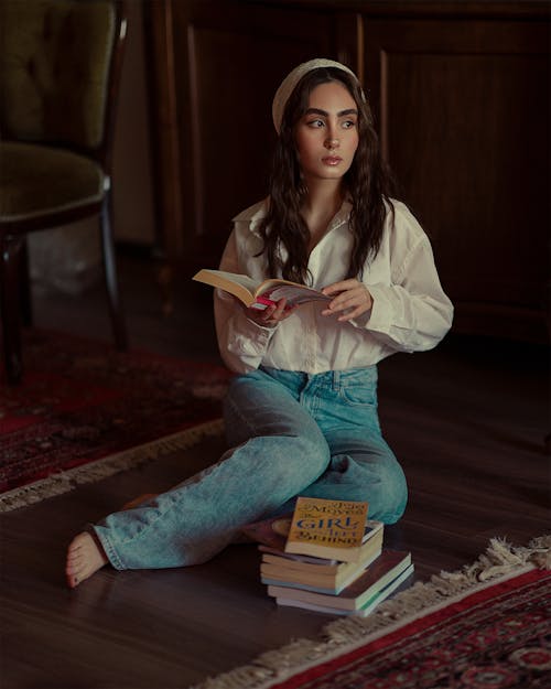 Woman Sitting on Floor and Posing with Books