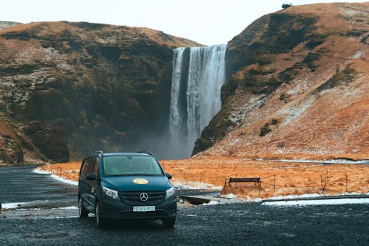 A tranquil view of a camper van parked near a majestic waterfall in Iceland.