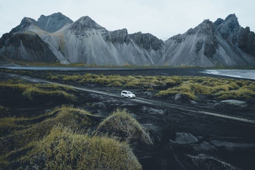 A car driving on a road near mountains